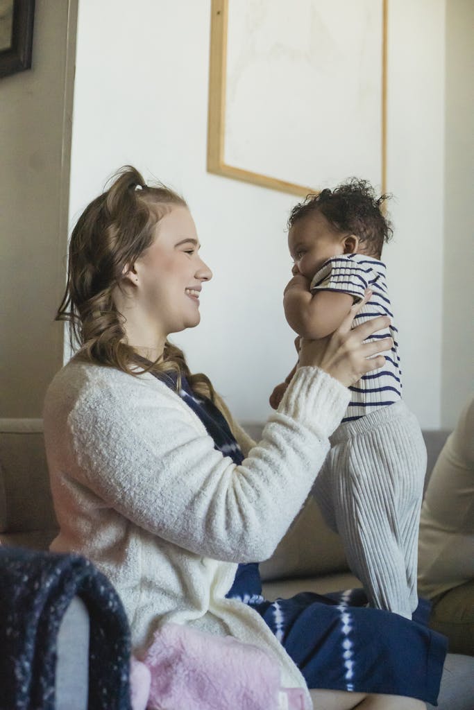 Optimistic mother with black baby in hands