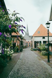 Idyllic European village with cobblestone streets, flowered gardens, and traditional architecture.